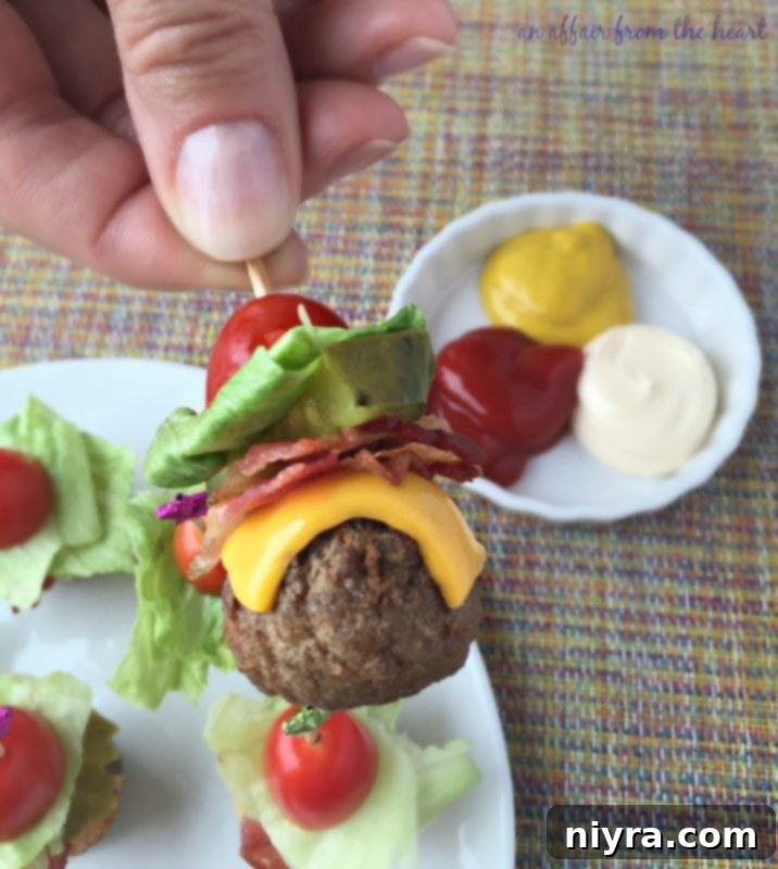 Close-up view of Bacon Cheeseburger Meatballs, garnished with a sprinkle of fresh green herbs, showcasing their savory appeal.
