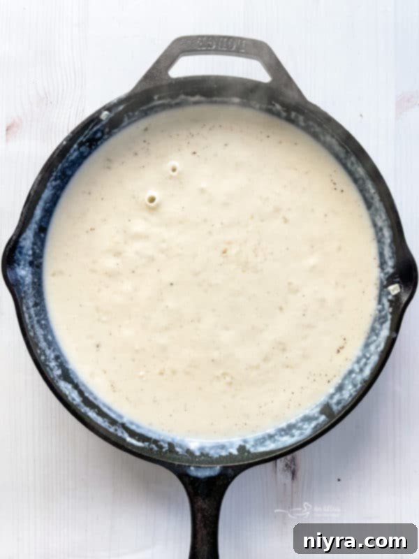 Easy Potatoes Au Gratin sauce in cast iron skillet for potatoes