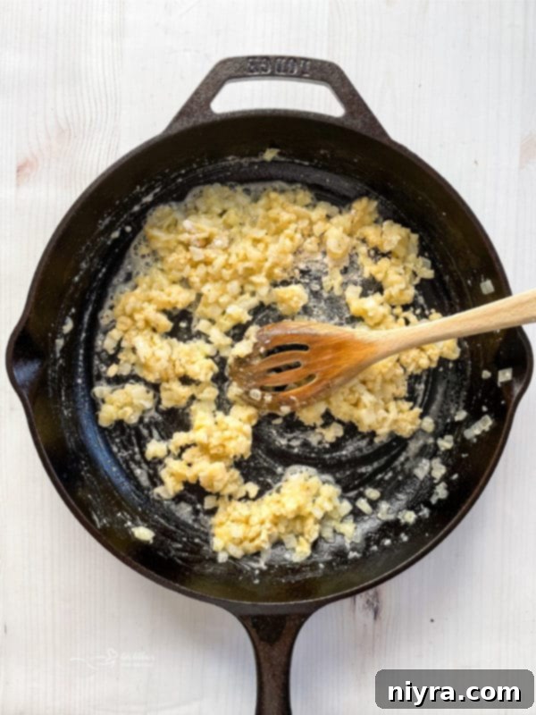 Easy Potatoes Au Gratin Recipe mixing flour and butter with onions and garlic in skillet with spoon