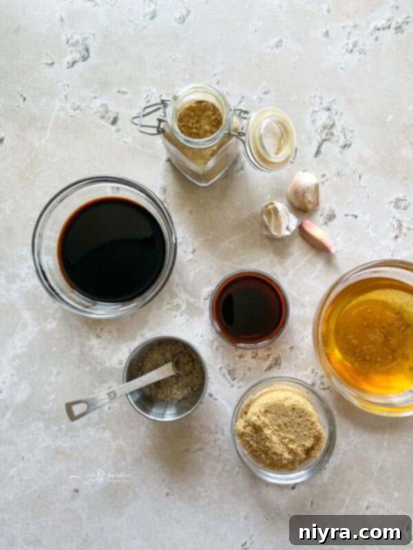 Close-up of three grilled chicken drumsticks, glistening with sticky sauce