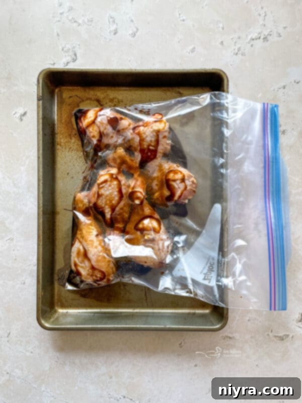 Ziploc bag with chicken and marinade, being shaken