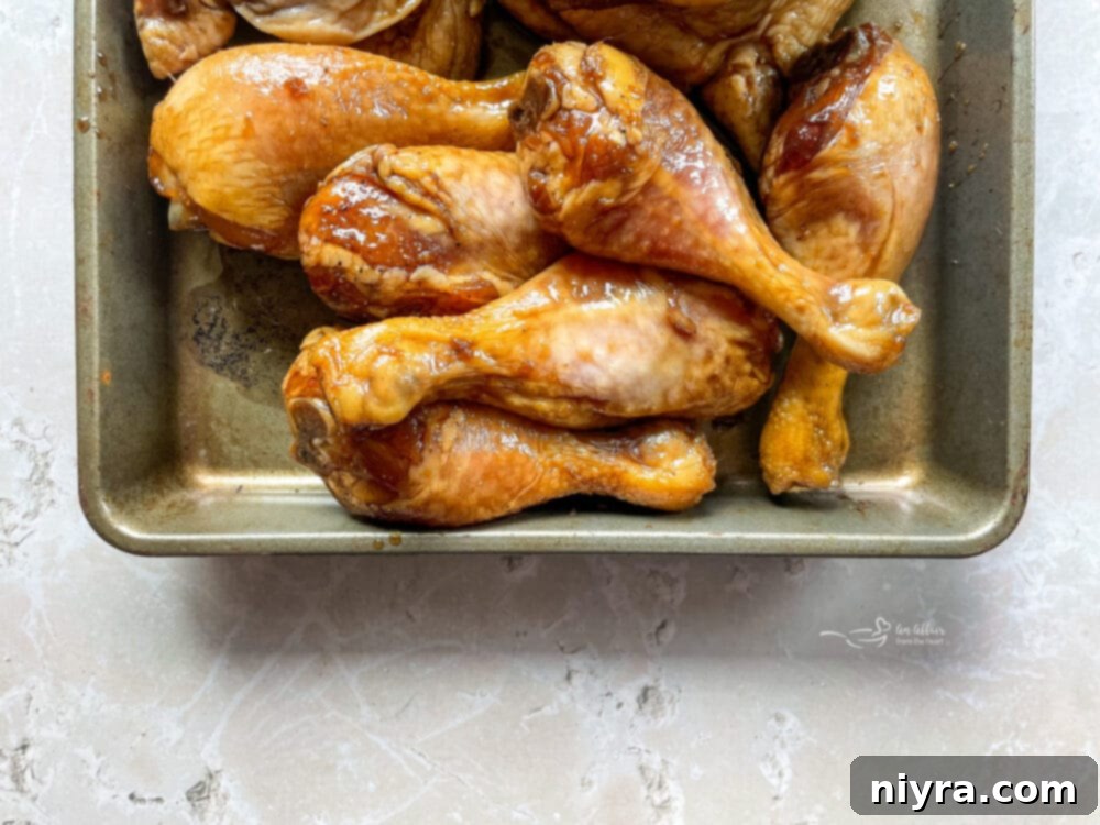 Close-up of basting brush applying glaze to grilled chicken