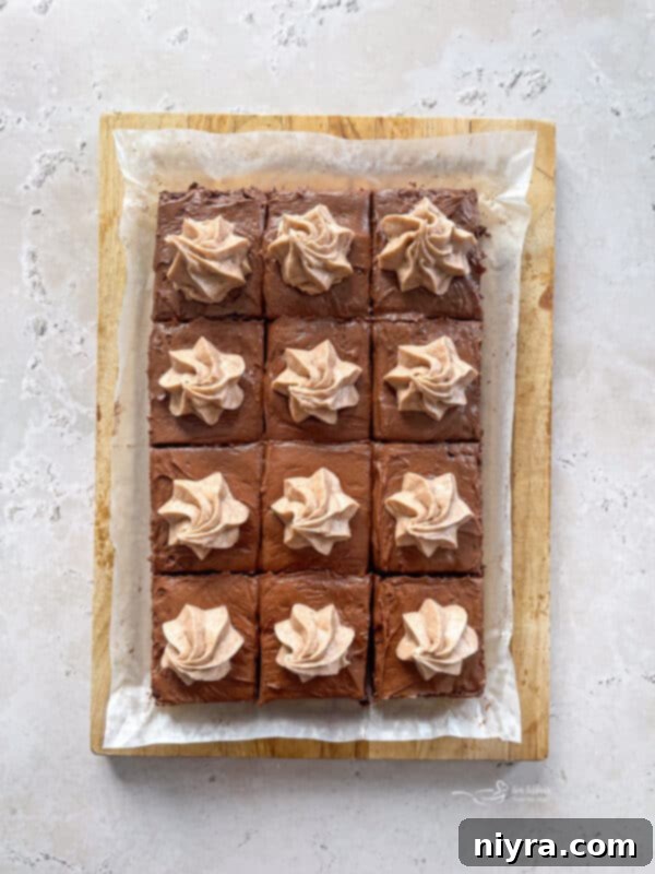 Piping cinnamon whipped cream onto brownies