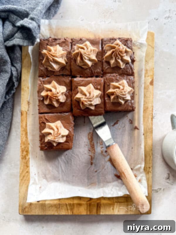 Mexican Chocolate Frosted Brownies sliced on a wooden board