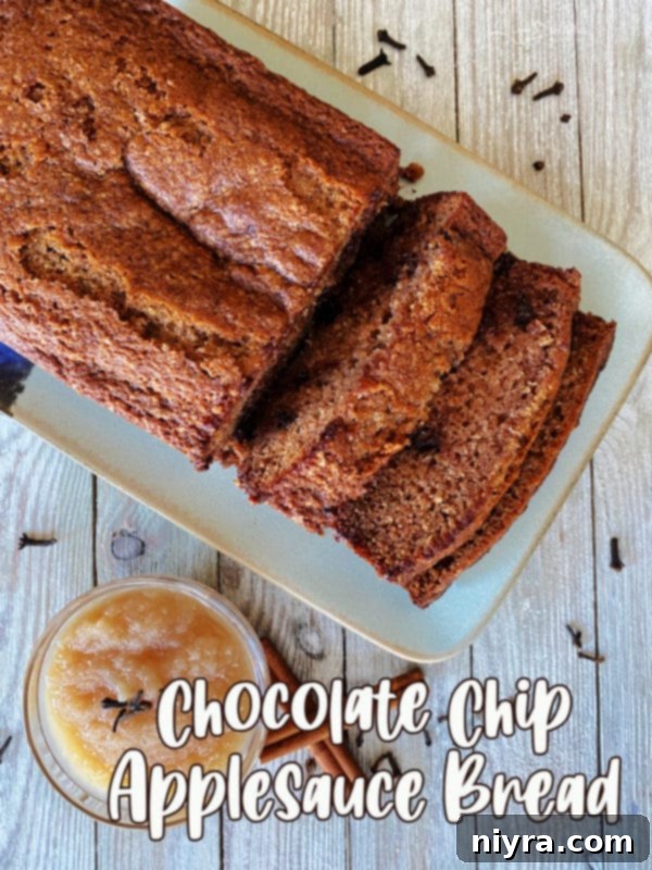 Top-down view of a delectable slice of applesauce bread with chocolate chips, artfully placed on a white plate, highlighting its moist texture and inviting appeal.