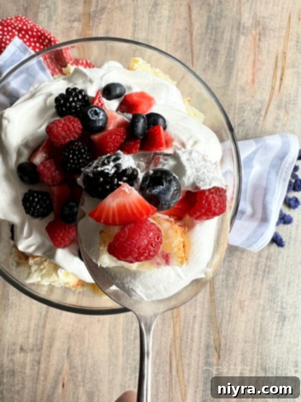 Serving a Berry Trifle into individual bowls with a large spoon