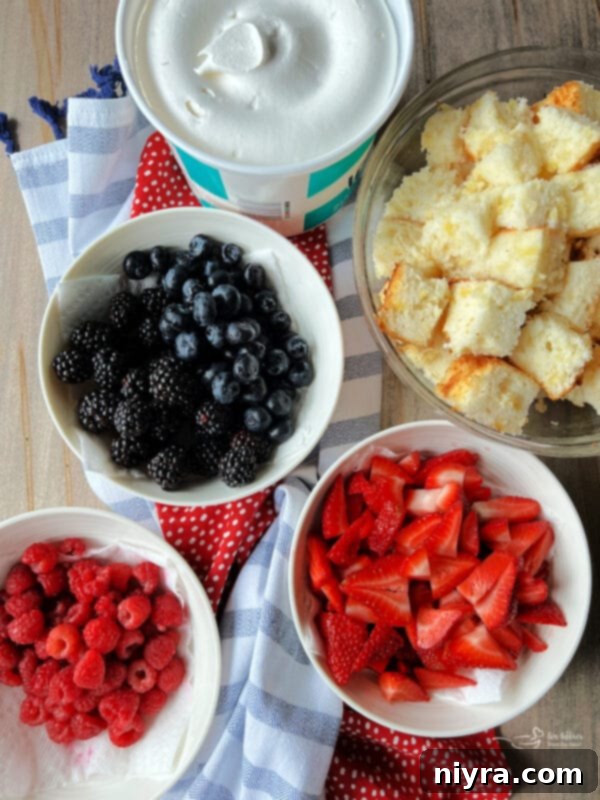 A spoonful of Triple Berry Trifle being lifted from a glass trifle bowl