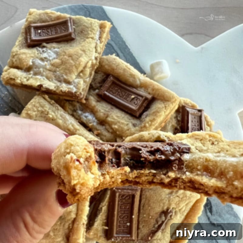 SMores Cookie Bars 13 A stack of S'mores Cookie Bars with a bite taken out