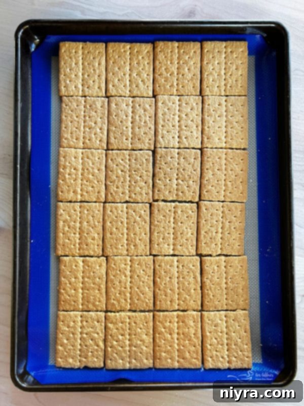 SMores Cookie Bars 6 Graham cracker squares arranged on a baking sheet with parchment paper