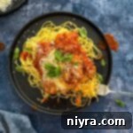 Easy Weeknight Chicken Parmesan on a dark colored plate.