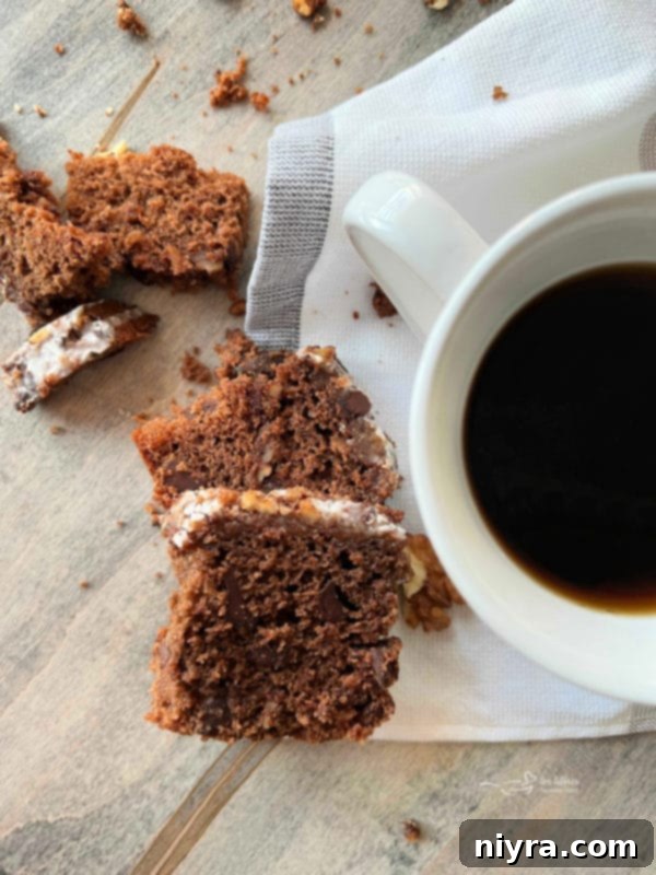 A generous slice of Bittersweet Chocolate Coffee Cake on a rustic plate, with a fork.