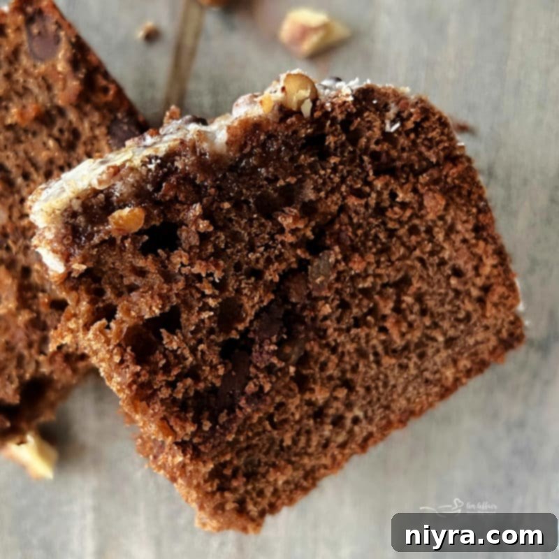 A slice of Bittersweet Chocolate Coffee Cake on a plate, with a fork, showing the moist interior.