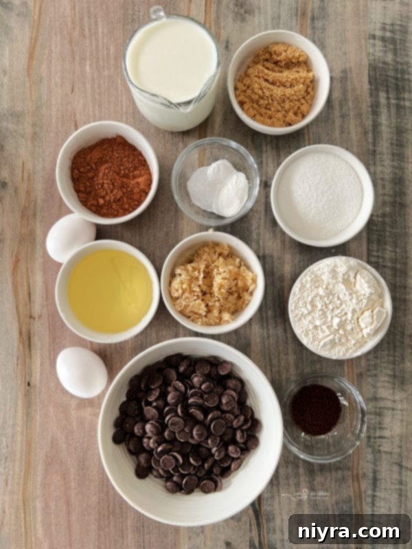 A large Bittersweet Chocolate Coffee Cake topped with streusel and white icing drizzle, on a white cake stand.