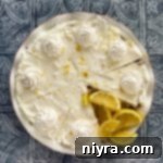 Lemon Icebox Pie with lemon wedges in the missing slice area.