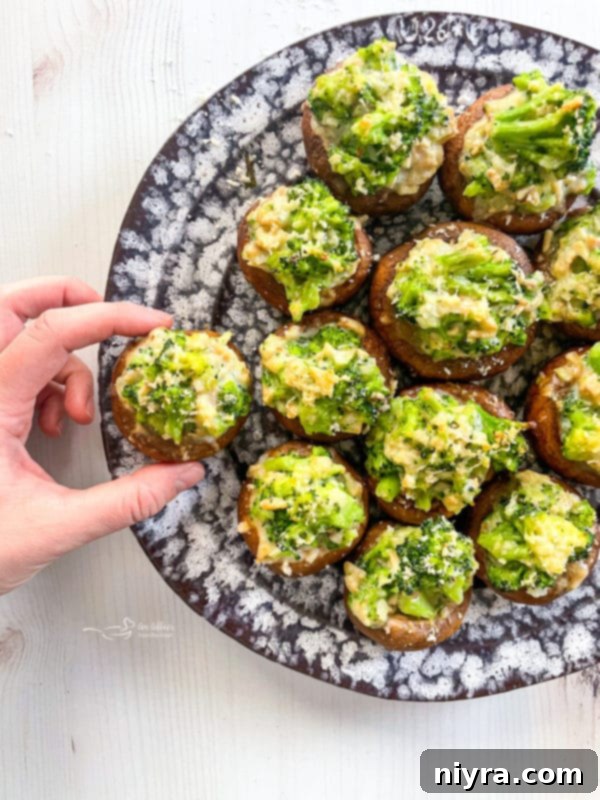 A serving of broccoli and cheese stuffed mushrooms, highlighting the cheesy topping.