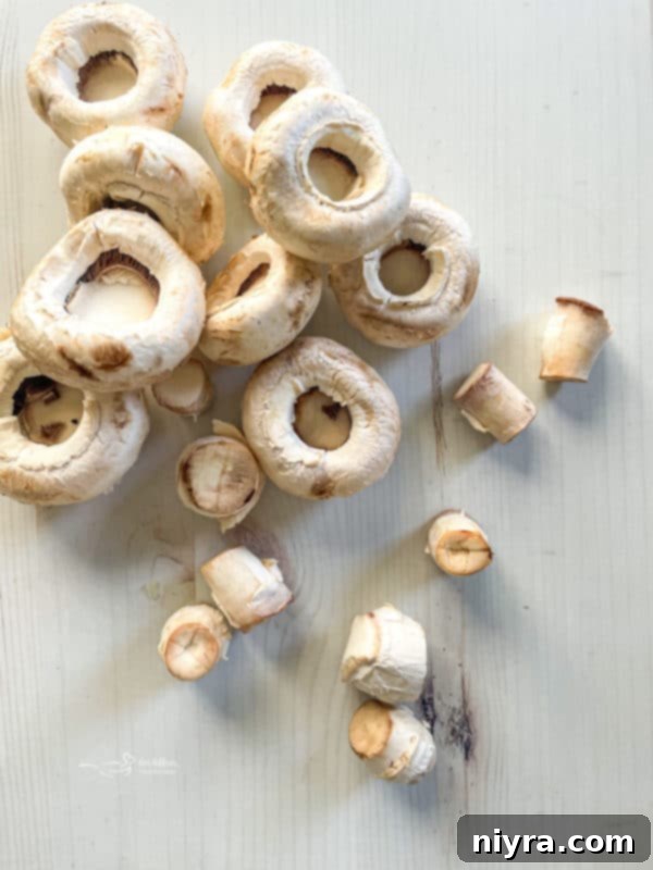 Cleaned mushroom caps laid out on a white surface, ready for stuffing.