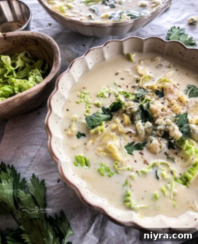 Close-up of creamy cabbage and blue cheese soup in a white bowl.