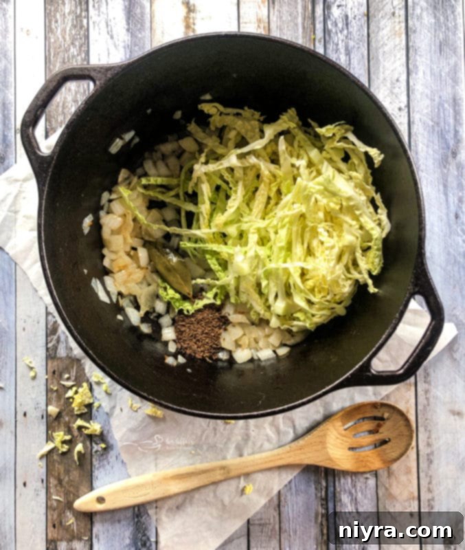 Onions and bay leaf sizzling in butter in a Dutch oven.