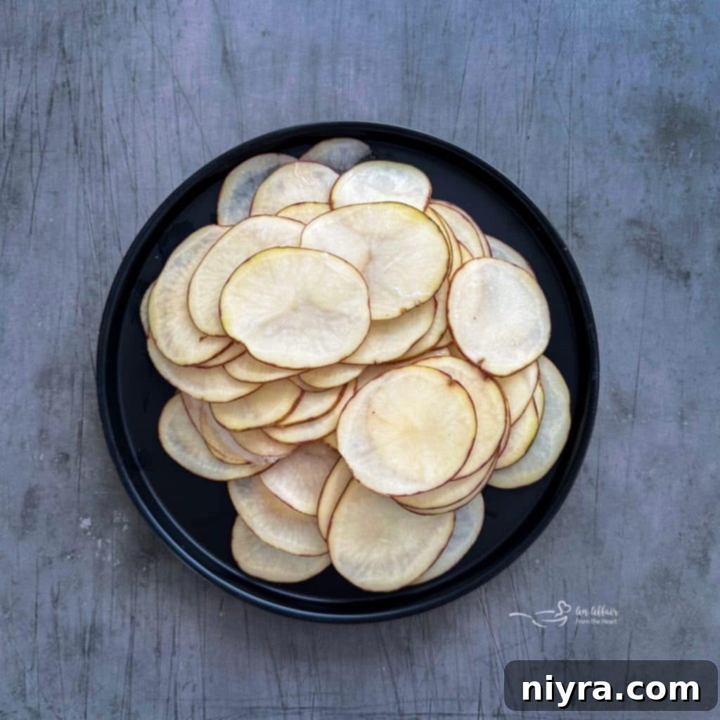 Potato slices being prepped on a mandoline