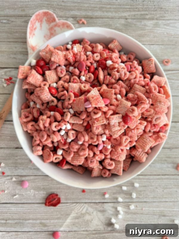 A white bowl filled with finished strawberry Chex mix, ready to serve.