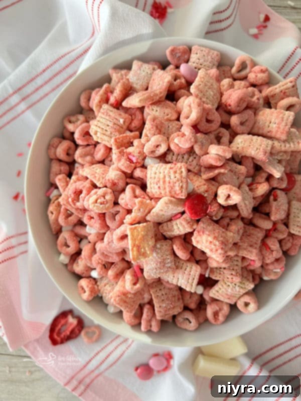 Top view of Rice Chex cereal in a bowl with other pink puppy chow ingredients scattered around.