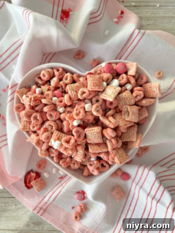 Top view of strawberry Chex mix arranged in a heart-shaped dish, perfect for Valentine's Day.