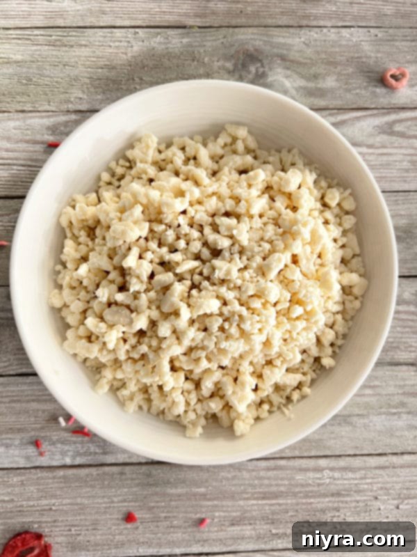 Powdered sugar and strawberry powder being mixed in a bowl with a whisk.
