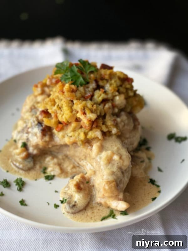white plate with baked pork chop with stuffing and gravy