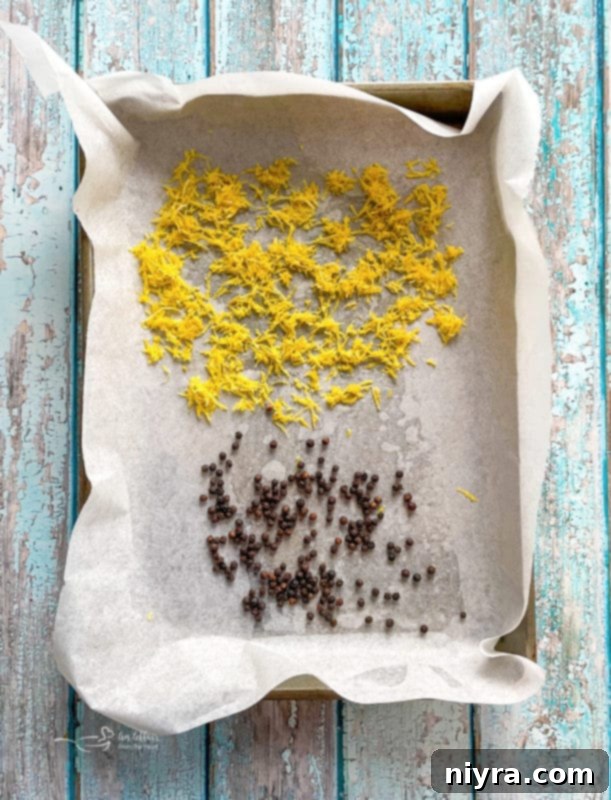 DIY Lemon Pepper Perfection 5 Lemon zest and black peppercorns spread on a parchment-lined baking sheet