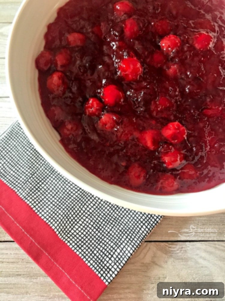 Overhead view of a vibrant Cherry Pie Jell-O Salad in a white serving bowl, ready to be enjoyed.