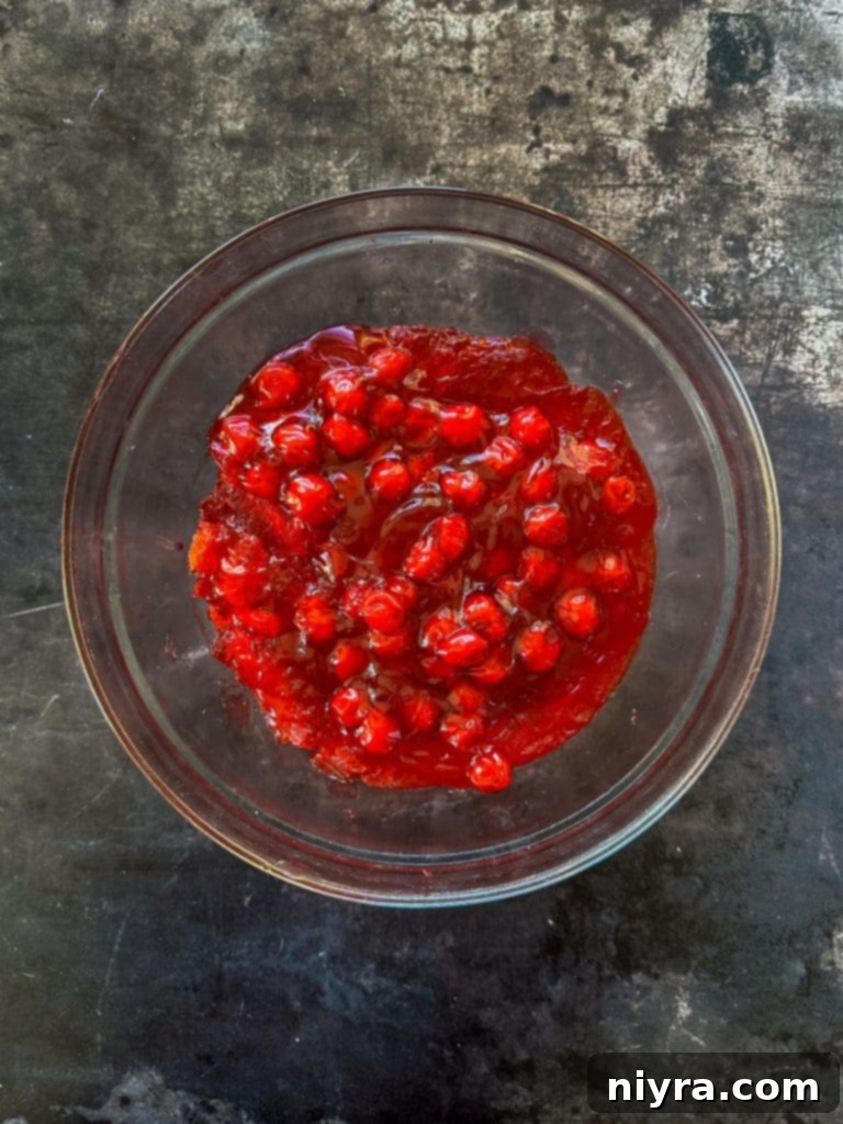 Close-up of the Cherry Pie Jell-O Salad showing its shimmering texture and embedded cherry pieces.