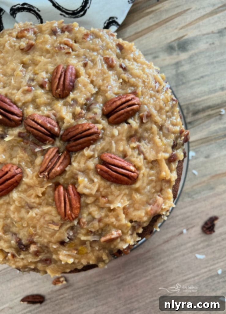 A completed three-layer German chocolate cake, beautifully frosted with rich coconut pecan icing between layers, ready for serving.