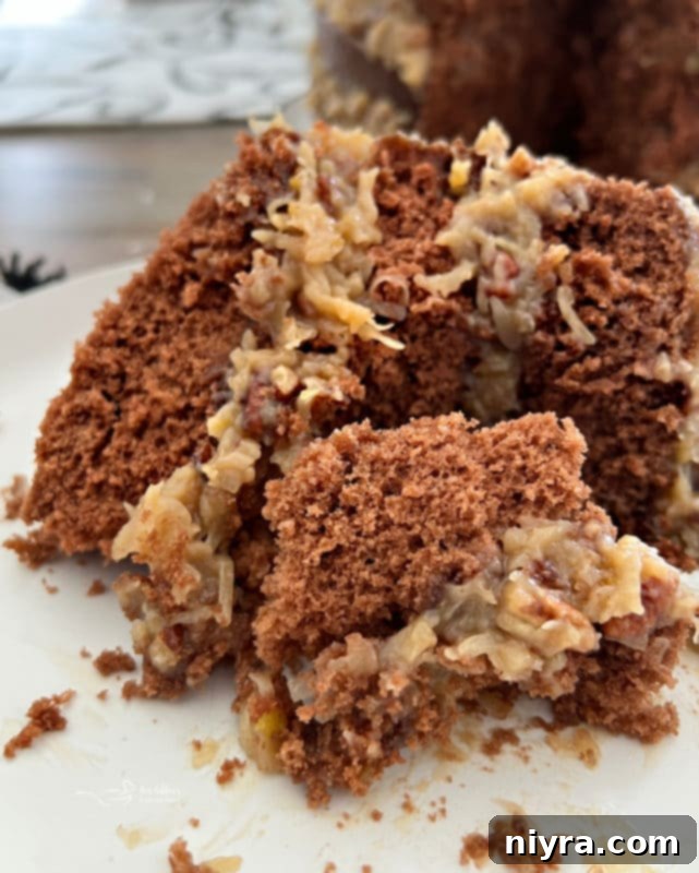 Close-up front view of a multi-layered German chocolate cake showcasing the luscious coconut pecan frosting between each rich chocolate layer.