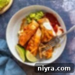 Fork cutting an enchilada to eat.