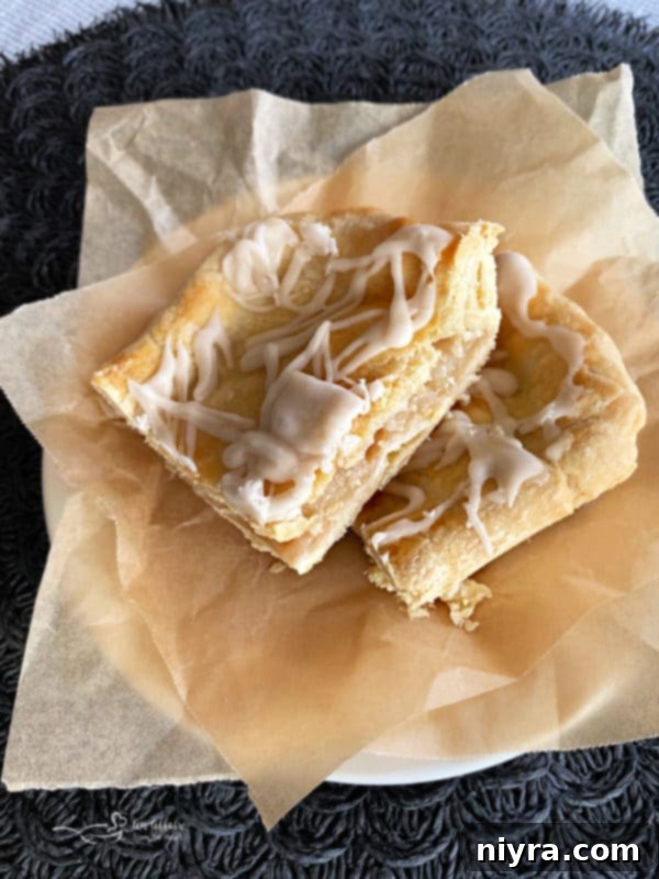 Hearty Spiced Raisin Bars 12 Apple Bars with icing on a plate