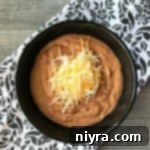 Overhead of Restaurant Style Refried Beans in a black bowl