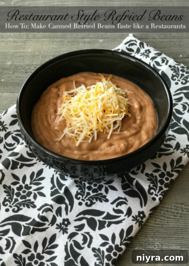 Restaurant Style Refried Beans in a white bowl with cheese and a tortilla