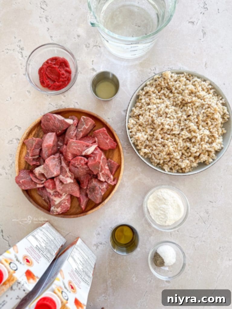 A bowl of Vegetable Beef Barley Soup with Mushrooms, featuring a rustic wooden background.