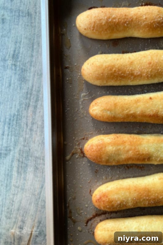 Baked Olive Garden Breadsticks on a baking sheet, golden brown and glistening with butter