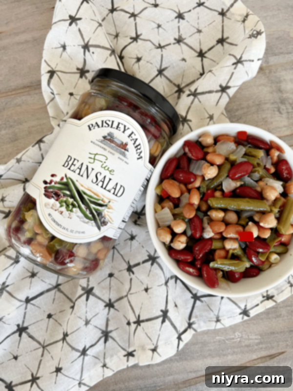Paisley Farm Five Bean Salad in a bowl with a spoon.