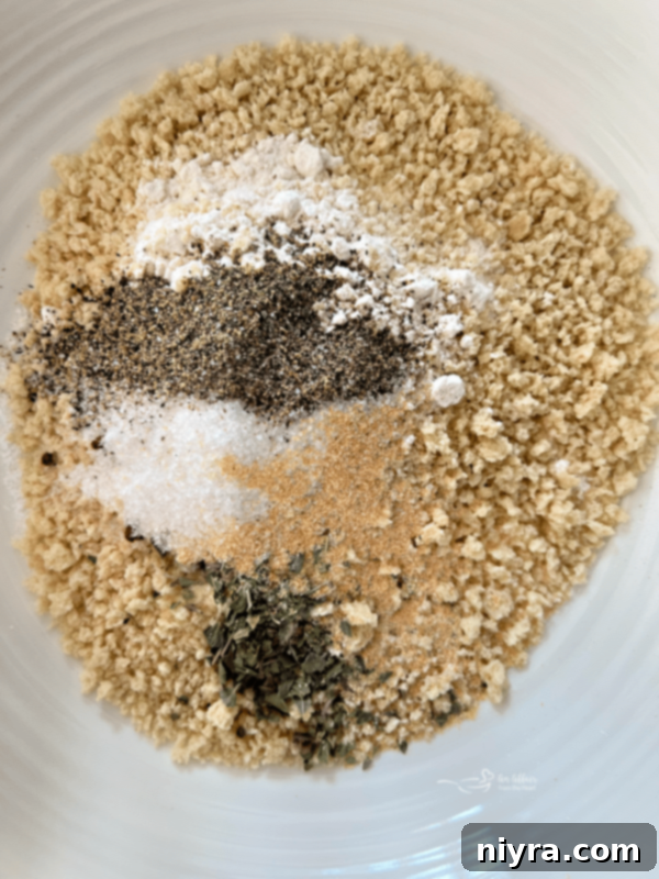 A shallow bowl with mixed breading ingredients: panko, flour, salt, pepper, paprika, garlic powder, and onion powder.