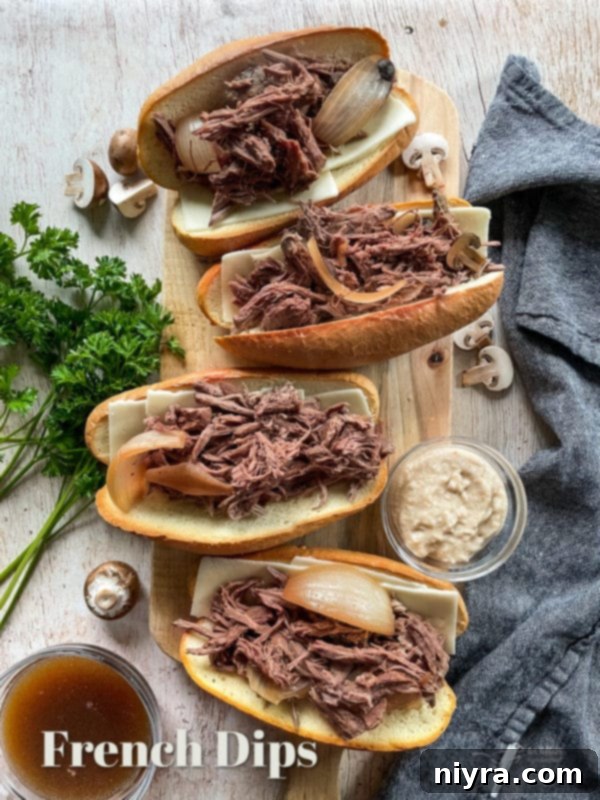A spread of delicious French Dip sandwiches on a cutting board, with small bowls of au jus for dipping, inviting a savory meal.