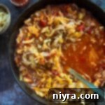 spooning out cabbage roll soup from the skillet