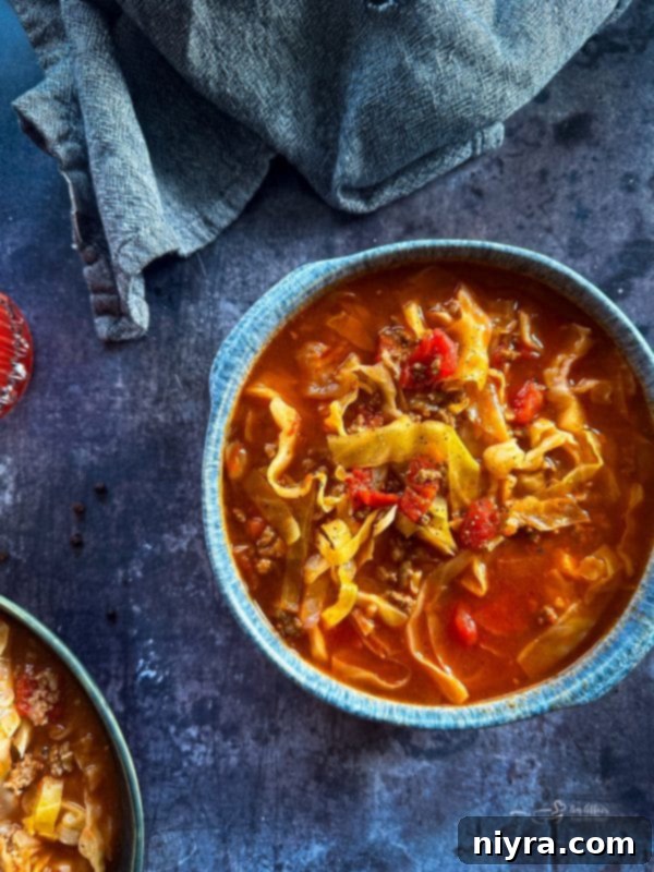 Cabbage Roll Soup in a white bowl with a spoon