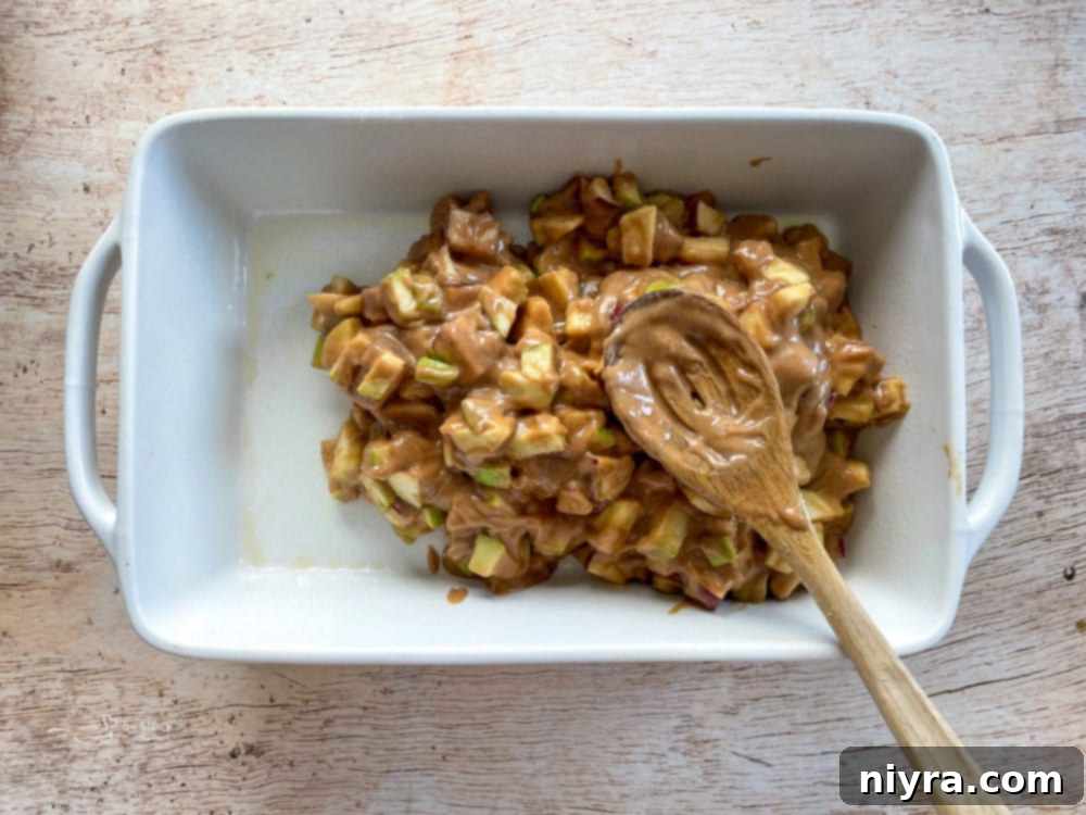 apple mixture being placed into dish with wooden spoon