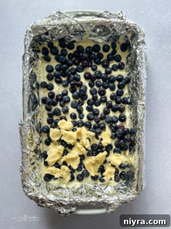Zesty Lemon Blueberry Crumb Bars 9 adding blueberries to unbaked cake mix