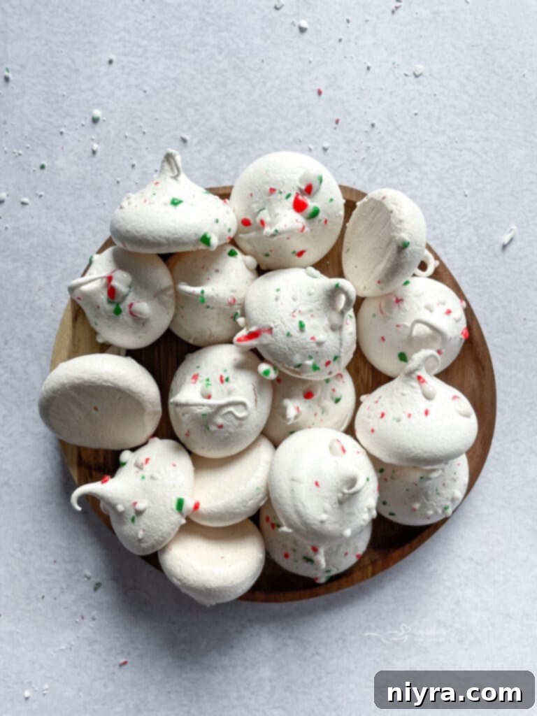 Delicate peppermint meringues arranged beautifully in a rustic wooden serving dish, ready to be enjoyed.