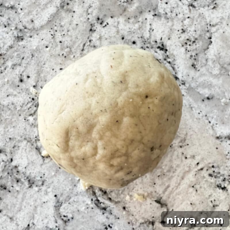 Lavender Shortbread and Lavender Strawberry Dream 13 Shortbread dough being kneaded by hand on a lightly floured surface to form a cohesive ball.