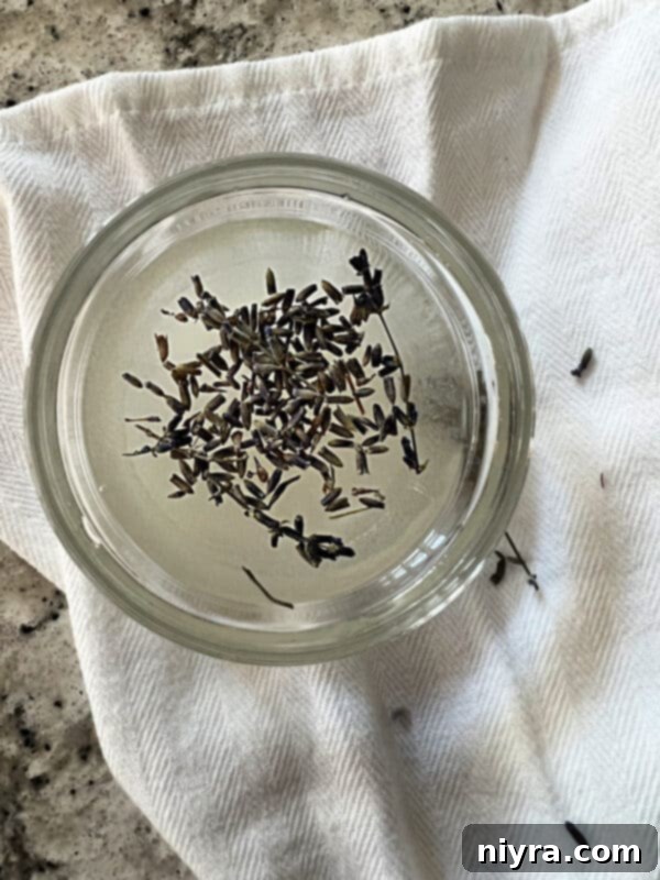 Lavender Shortbread and Lavender Strawberry Dream 18 Clear glass jar with fresh lavender sprigs and a simple syrup, with a label indicating 'Lavender Syrup'.