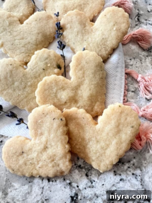 Lavender Shortbread and Lavender Strawberry Dream 10 Freshly cut, uncooked lavender shortbread dough in various shapes arranged on a parchment-lined baking sheet.
